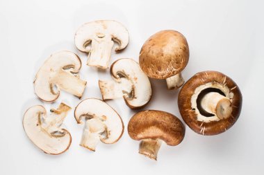 Bir yığın beyaz arka plan üzerinde izole kahverengi champignon bütün ve dilimlenmiş mantar