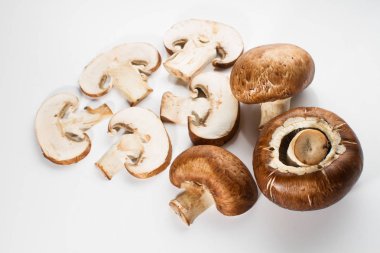 Bir yığın beyaz arka plan üzerinde izole kahverengi champignon bütün ve dilimlenmiş mantar