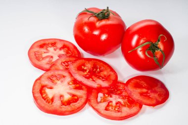 Beyaz arka plan üzerinde izole bütün ve dilimlenmiş domates