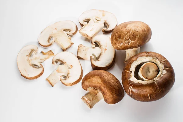 Bir yığın beyaz arka plan üzerinde izole kahverengi champignon bütün ve dilimlenmiş mantar