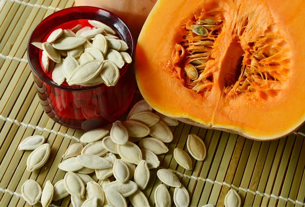 dried pumpkin seeds are snacks that  healthy. dried pumpkin seeds with fresh pumpkin on Bamboo mat background