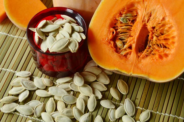 dried pumpkin seeds are snacks that  healthy. dried pumpkin seeds with fresh pumpkin on Bamboo mat background
