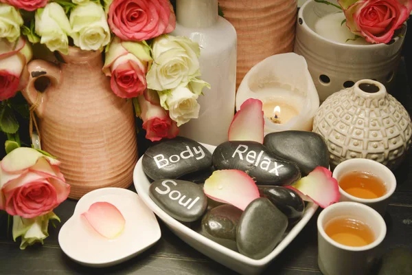 Roses spa with candle lightSpa equipment with pink and white roses on the black wooden tray
