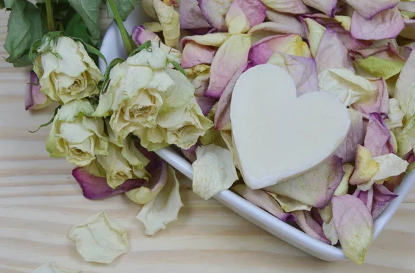 dried white roses and petal with candle heart shape (lens blur)