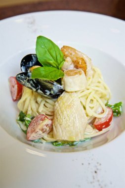 Somonlu spagetti, parmesan peyniri ve fesleğenli, soslu ve domatesli makarna. Stüdyo fotoğrafı