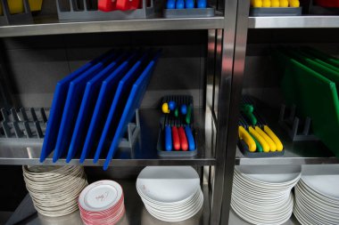 Düzgün depolanmış renkli kesme tahtaları ve çatal bıçakları