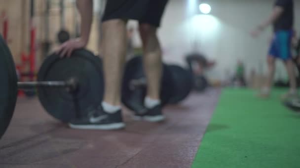 crossfit trénink vzpírání, silní muži trénují v tělocvičně, skupina lidí