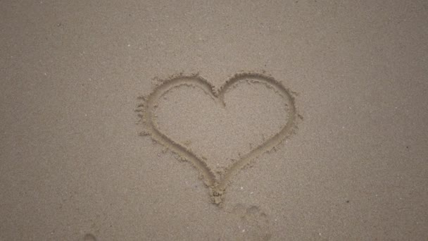 Ein Vom Sand Gezeichnetes Herz Wird Von Der Welle Weggespült — Stockvideo