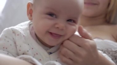 Bebek, küçük kız ve anne, yatakta rahatlayın, gülümsüyor, sevinir,