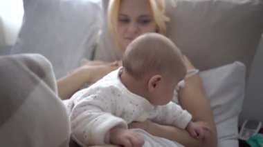Bebek, küçük kız ve anne, yatakta rahatlayın, gülümsüyor, sevinir,