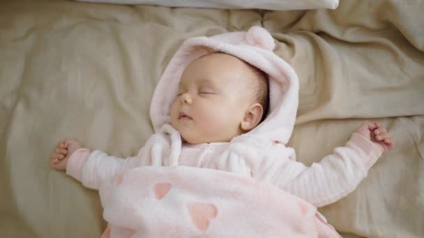 Cute baby, little girl sleeps on the bed, smiles, rejoices, worries, cries — Stock Video