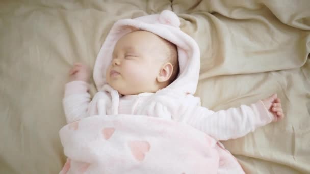 Bébé mignon, petite fille dort sur le lit, sourit, se réjouit, s'inquiète, pleure — Video