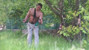 Kaslı, çıplak gövdeli, çim biçen yakışıklı bir adam.