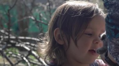 Güzel bir kız, 3 yaşında, büyükannesinin ona verdiği bir kedi yavrusuyla tanışıyor.