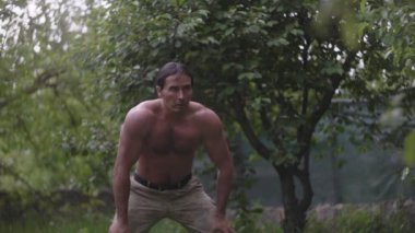 Sokakta duran yakışıklı bir sporcu. Eğitimden sonra dinlenen asker pantolonlu güçlü genç adam. Crossfit, fitness, sağlıklı