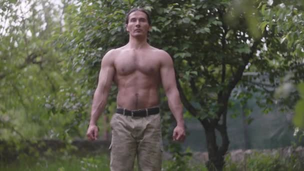 Az izmos férfi bemelegít edzés előtt. Egy bennszülött amerikai férfi álcázó nadrágban. — Stock videók