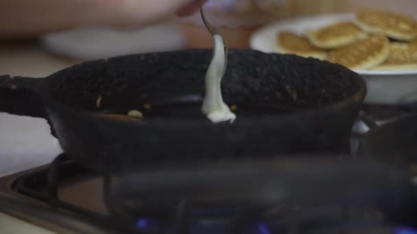 Woman cooking pancake on an old frying pan, roasts pancakes — Stock Video