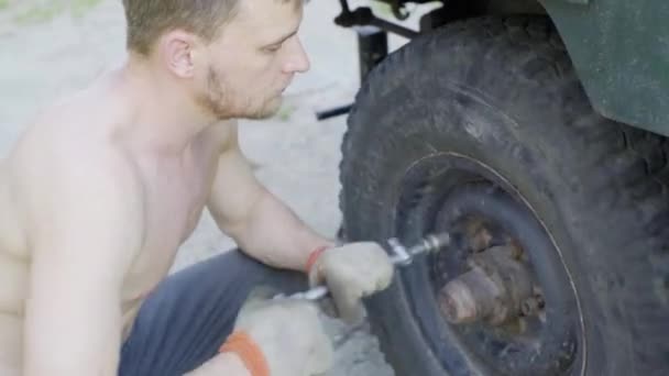 机械师在一辆旧车上安装了一个轮子,特写镜头 — 图库视频影像