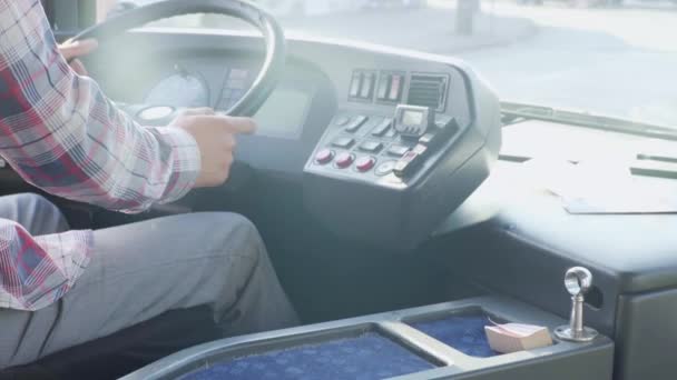 Motorista de ônibus masculino em uma camisa xadrez, no verão, monta um ônibus na estrada, coleta companheiros de viagem — Vídeo de Stock