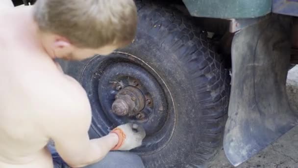 男人在一辆旧车上装了个轮子，特写镜头 — 图库视频影像