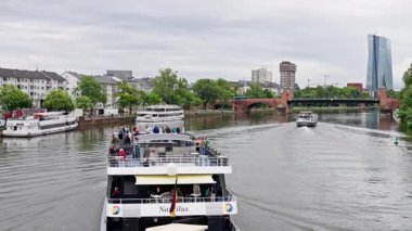 Delight in the stunning water views showcasing boats and sleek modern architecture along Frankfurts scenic riverbanks