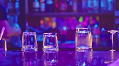 A vibrant and lively bar scene showcasing filled glasses and a colorful backdrop thats beautifully illuminated. High quality 4k footage