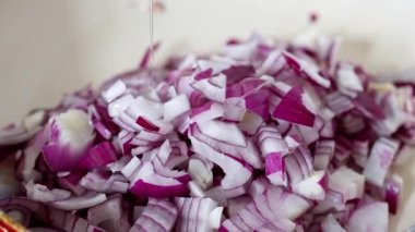 Freshly chopped red onions are being mixed with water, making them ideal for both cooking and enhancing salads