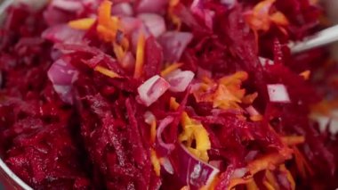 A colorful dish is expertly prepared in a pan with freshly shredded beetroots and various garnishes. High quality 4k footage