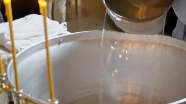 İçindeki bebeklerin vaftiz töreni için kutsal suyla dolu alüminyum bir küvet. Yüksek kalite 4k görüntü