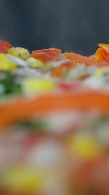 Ağzını sulandıran pizzayı renkli sebzeler ve aromatik otlarla kapat. Tüm yemek severler için mükemmel. Yüksek kalite 4k görüntü