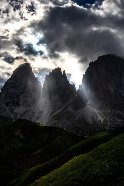 sella üzerinde bulutların arasından güneş ışınları dolomites içinde fırtına sırasında geçmek.