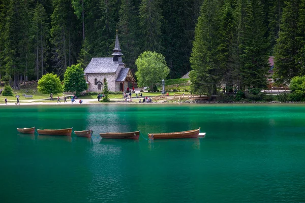 kürekli tekneler arka planda bir kilise ile Braies Gölü sud tyrol İtalya, görünümünü. Göl, Bolzano eyaletinin doğal bir parkta croda di becco denilen dağ altında yer alır. Bu, s renkler için bir ünlü turistik hedef su