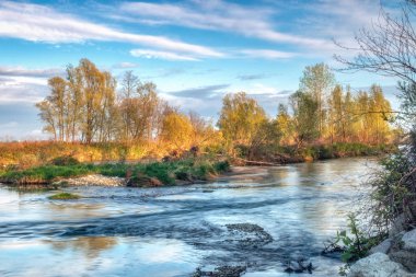 nehir üzerinde ağaçların renkli yansımaları