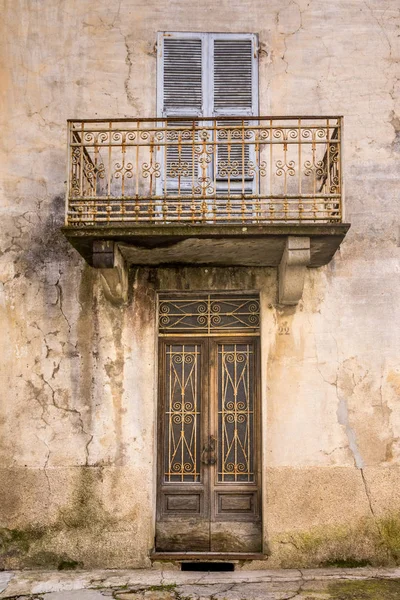 Old building facade with wooden door and balcony — Stock Photo, Image