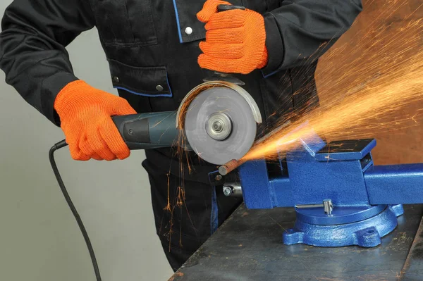 Sanayi işçisi değirmeni ile metal kesme. Parlak kıvılcımlar bir sürü