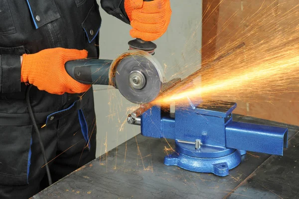 Sanayi işçisi değirmeni ile metal kesme. Parlak kıvılcımlar bir sürü