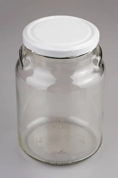 Pusty szklany słoik z białą pokrywą izolowaną na szarym tle — Zdjęcie stockowe