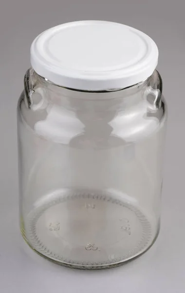 Empty glass jar with white cover isolated on gray background