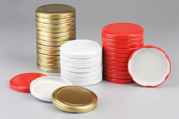 各种玻璃罐的螺帽。用于罐头、罐头食品。白色、红色、金色的黑色帽子在灰色背景 — 图库照片