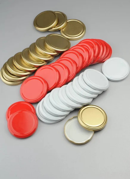 Various screw caps for glass jars. For canning, canned food. White, red, golden caps on gray background — Stock Photo, Image