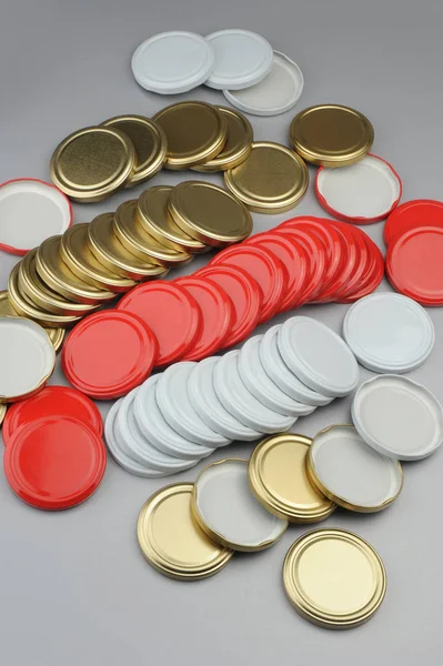 Különböző csavaros sapkák üvegedény. Konzervezés, konzerv élelmiszer. Fehér, piros, arany sapkák szürke háttérrel — Stock Fotó
