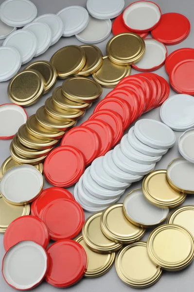 Várias tampas de rosca para frascos de vidro. Para conservas, comida enlatada. Branco, vermelho, bonés dourados no fundo cinza — Fotografia de Stock