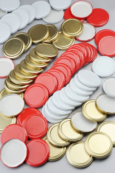 各种玻璃罐的螺帽。用于罐头、罐头食品。白色、红色、金色的黑色帽子在灰色背景 — 图库照片