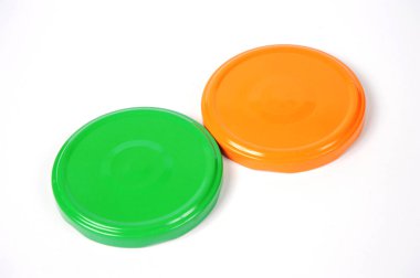 Cam kavanozlar için vida kapakları. Konserve için. Turuncu, beyaz arka planda yeşil kapaklar