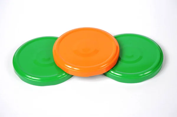 Bouchons à vis pour pots en verre. Pour la mise en conserve, la nourriture en conserve. Casquettes orange, vertes sur fond blanc — Photo