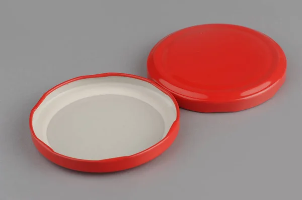 Screw caps for glass jars. For canning, canned food. Red caps on gray background — Stock Photo, Image