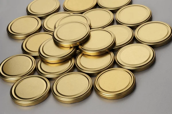 Screw caps for glass jars. For canning, canned food. Golden caps on gray background — Stock Photo, Image