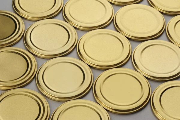Schraubverschlüsse für Glasgefäße. für Konserven, Konserven. goldene Kappen auf grauem Hintergrund — Stockfoto