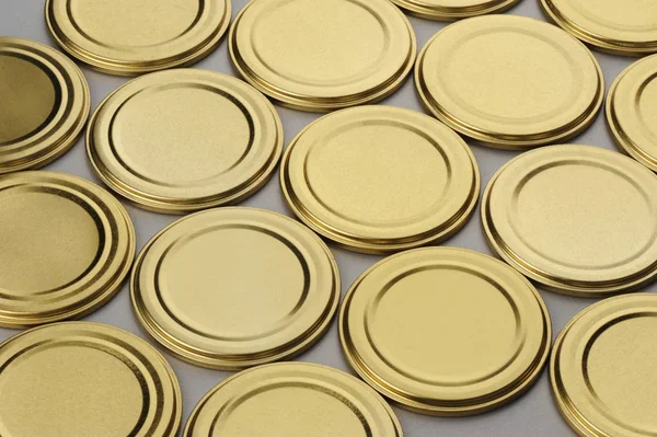 Screw caps for glass jars. For canning, canned food. Golden caps on gray background — Stock Photo, Image