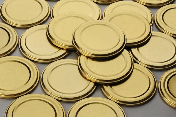 Screw caps for glass jars. For canning, canned food. Golden caps on gray background — Stock Photo, Image